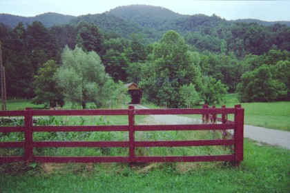 Looking over fence at covered bridge in background