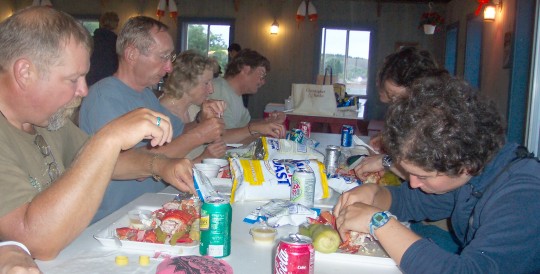 Group seated at table, cracking lobster shells