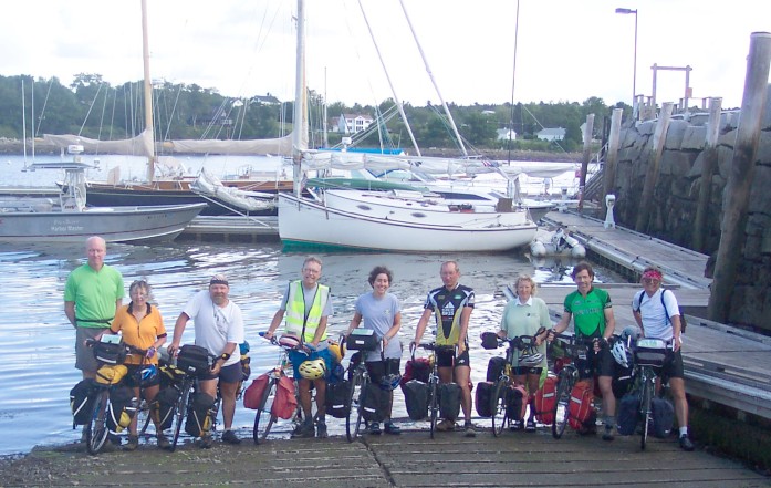 Group at end of boat ramp with boats in background