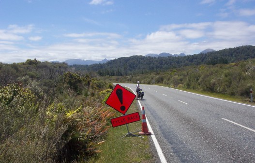 Sue and a caution sign for bicycle race