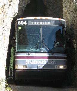 Bus inching through tunnel through rock with inches to spare