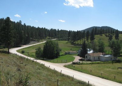 Pretty scene looking down on gravel road, fields and homes