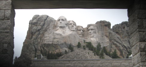 4 faces of Mt. Rushmore framed by stone archway