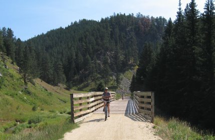 Rider esiting bridge that has wood railings on both sides