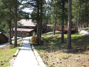 Concrete walkway leading downhill toward two-story building