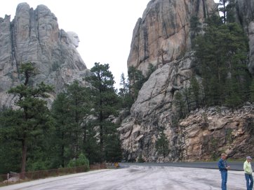 Parking lot in foreground, V-shaped valley in distance with Washington's head carved on left cliff face