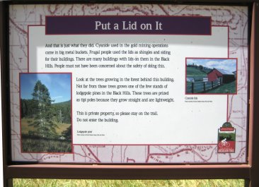 Signboard 'Put a Lid on it' with info about barn tiled with lids