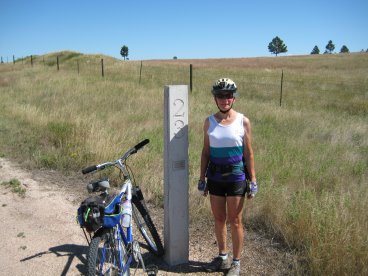 Sue standing beside swuare concrete post labeled '23'
