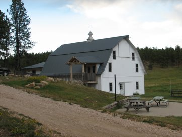 Large, white barn with cross on roof