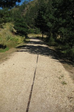 Trail with a rail showing through the gravel