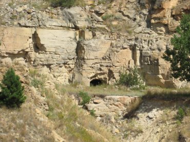 Mine entrance cut into the bottom of a rock cliff