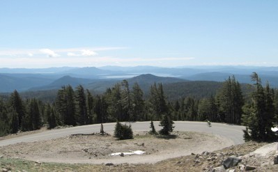Cyclist on the road below with Lake Almanor in the distance