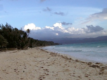 Beach curving off in the distance with clouds