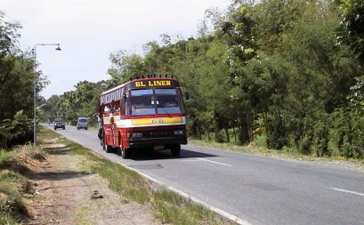 Bus with '6L Liner' sign on country road