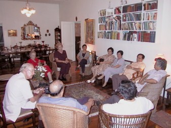 Guests seated in a circle talking in Dave and Hazel's living room