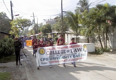 Small group of students marching in street with banner that reads, 'CPU College of Law, CPU University Day 2000'