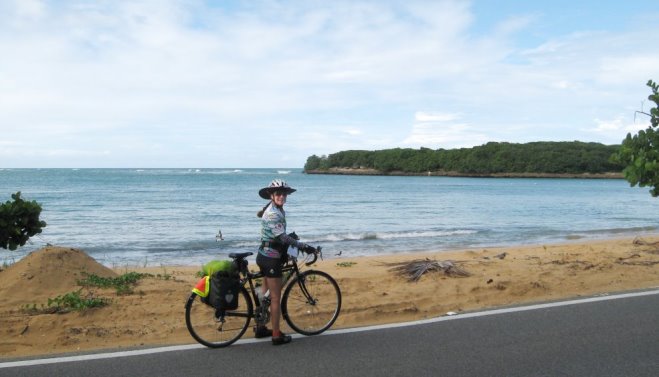 Sue on bike in front of beach