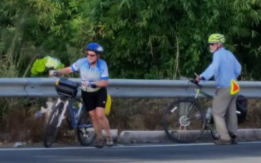 Patty & Doug walking bikes up the hill