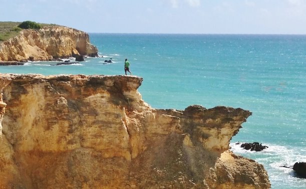 Cliffs and sea with man standing on cliff